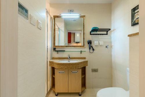 a bathroom with a sink and a mirror at Dalian Baobab Apartment in Dalian