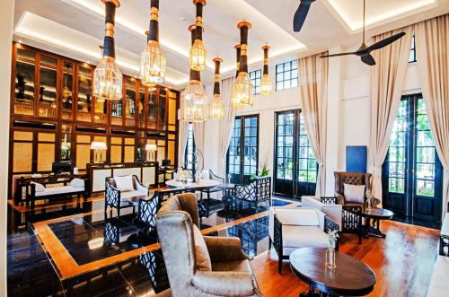 - un salon avec de nombreux meubles et fenêtres dans l'établissement Buri Sriping Riverside Resort & Spa - SHA Extra Plus, à Chiang Mai