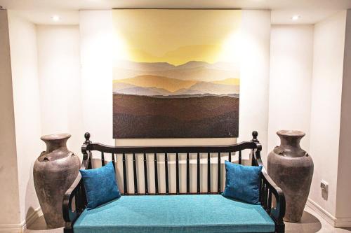 a bench in a room with two vases at Buri Sriping Riverside Resort & Spa in Chiang Mai