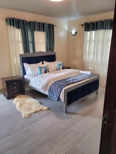 - une chambre avec un grand lit et un tapis dans l'établissement Gloria House, à Nairobi