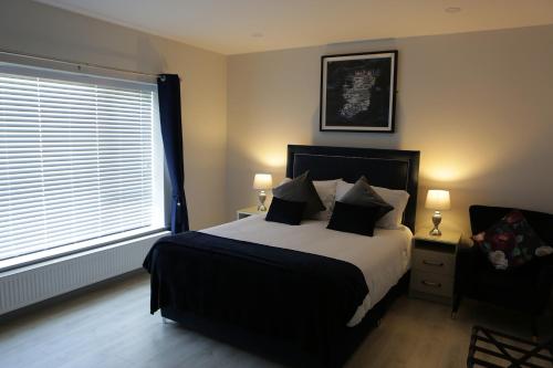 a bedroom with a large bed and a window at Causeway guest accommodation in Bushmills