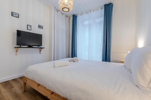 a bedroom with a bed and a flat screen tv at Joli T2- cocooning - wifi fibre - lave-linge in Grenoble