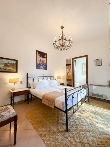 a bedroom with a bed and a chandelier at Villa La Petite Etoile in Torre delle Stelle