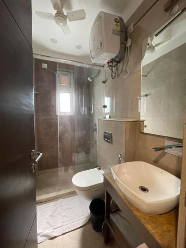 a bathroom with a sink and a toilet and a shower at Wongdhen House in New Delhi