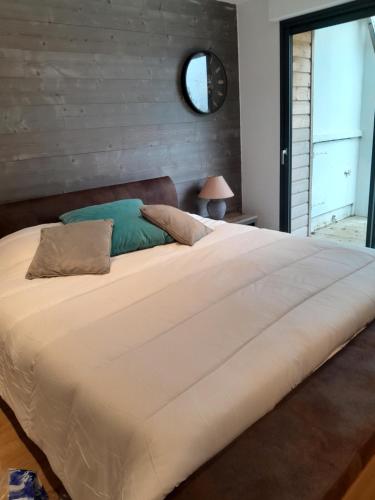 1 cama blanca grande en un dormitorio con ventana en Au delà des Remparts en Montreuil-sur-Mer