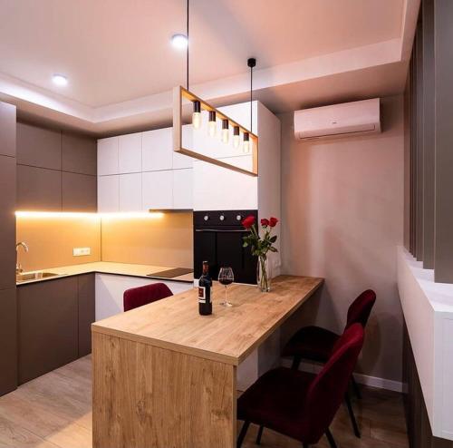 Una cocina con una gran isla de madera con sillas rojas. en ЖК Веst House, en Dnipro