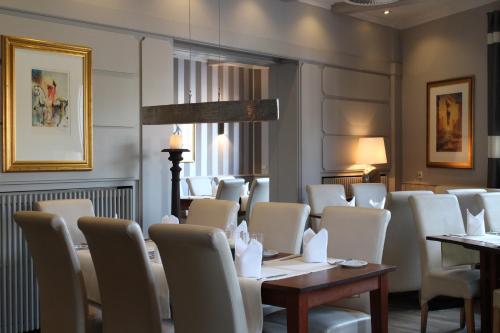 a dining room with white chairs and a table at Hotel-Restaurant Große-Wilde in Bottrop