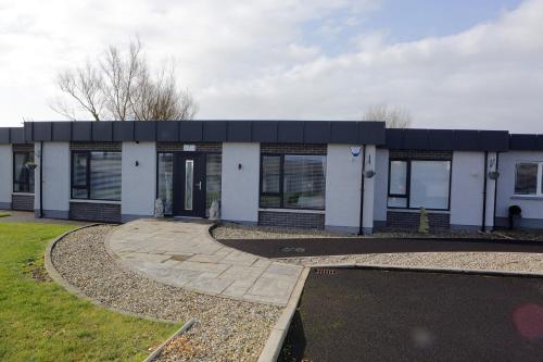 a white building with a black roof at Causeway guest accommodation in Bushmills