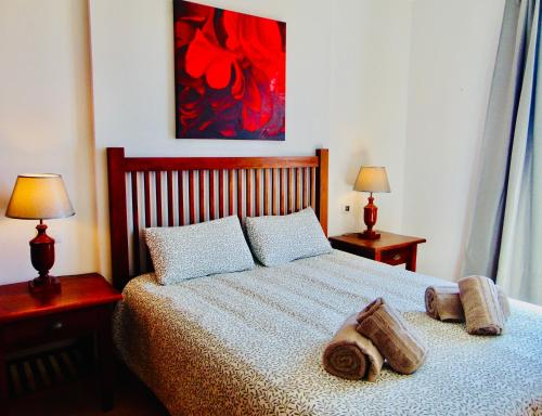 1 dormitorio con 1 cama con 2 lámparas y 1 pintura en Brisa Del Mar Fuerteventura, en Puerto del Rosario