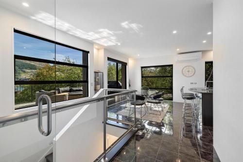an open kitchen and living room with large windows at Luxurious Lake View Escape in Frankton Wharf