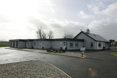a large white building with a parking lot at Causeway guest accommodation in Bushmills