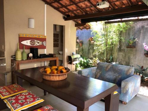 a living room with a table and a bowl of fruit at Casa em Arraial d’Ajuda in Porto Seguro