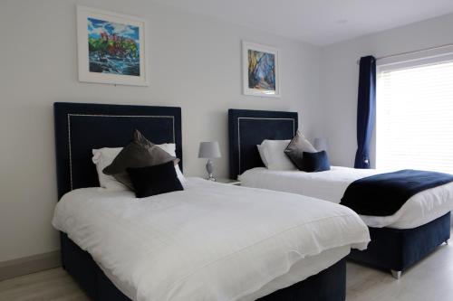 two beds in a room with white and black at Causeway guest accommodation in Bushmills