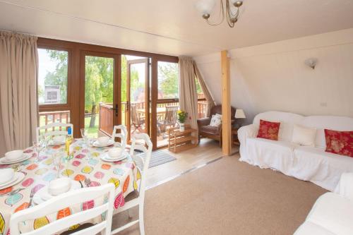 a living room with a table and a couch at Chalet 98 in Deal