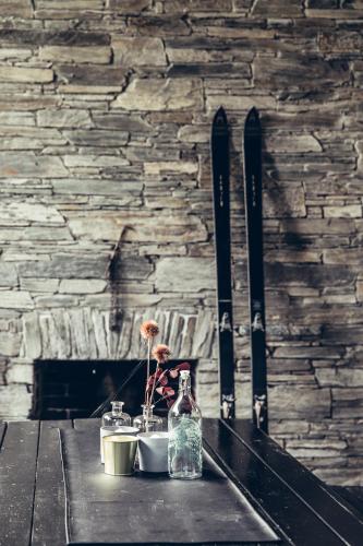 a table with skis and a bottle and flowers on it at Bungalow „Zeitlos am Berg“ auf der Hochrindl in Sirnitz-Sonnseite