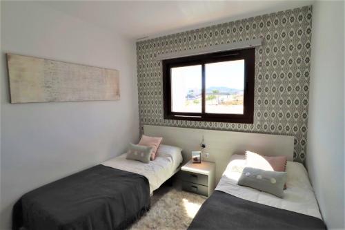 a bedroom with two beds and a window at CASA MILA, precioso apartamento in San Juan de los Terreros
