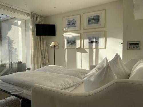 ein weißes Bett in einem Zimmer mit Fenster in der Unterkunft Strandgut in Rostock