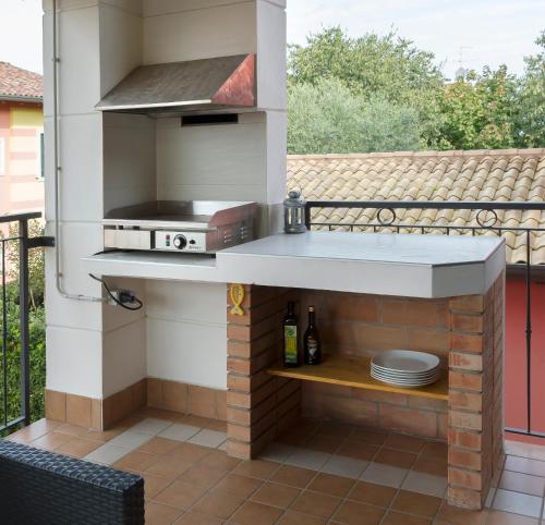 une cuisine extérieure avec un grill et des assiettes sur une terrasse dans l'établissement Casa vacanza Simona, à Salionze