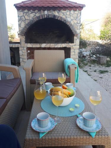 a table with a bowl of fruit and glasses of wine at Spider Apartments in Pirovac