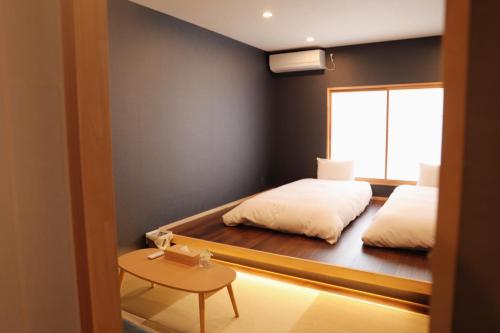um pequeno quarto com duas camas e uma mesa em 千本南大阪で日本の伝統的な文化を感じられる雰囲気 em Osaka