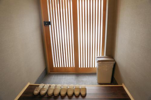 uma fila de sapatos sentados à frente de uma porta em 千本南大阪で日本の伝統的な文化を感じられる雰囲気 em Osaka