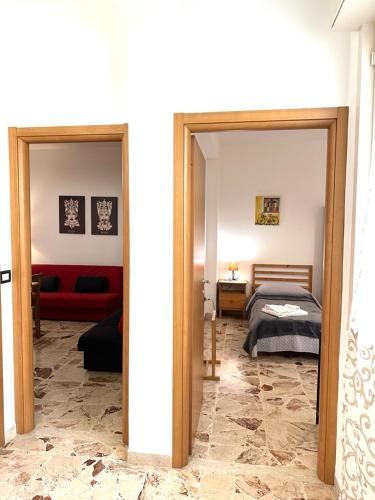 um quarto com uma cama e um sofá vermelho em Il Rifugio Storico in Piazza em Augusta