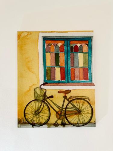uma pintura de uma bicicleta estacionada em frente a uma janela em Il Rifugio Storico in Piazza em Augusta
