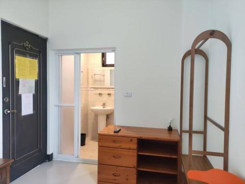 um quarto com uma cómoda, um espelho e uma porta em Dahu Yipinyuan B&B em Ta-hu