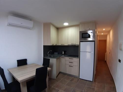 uma pequena cozinha com uma mesa e um frigorífico em Casa Xavier - Apartamento 2 em Ager