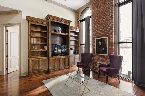 uma sala de estar com duas cadeiras e uma parede de tijolos em Chuck's Place em Nova Orleans