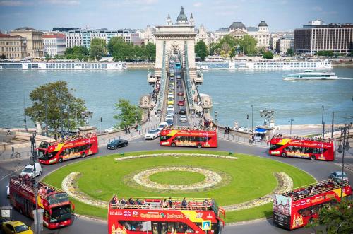 a group of double decker buses in front of a tower at Skylark Cozy Bigger Apartment in Budapest