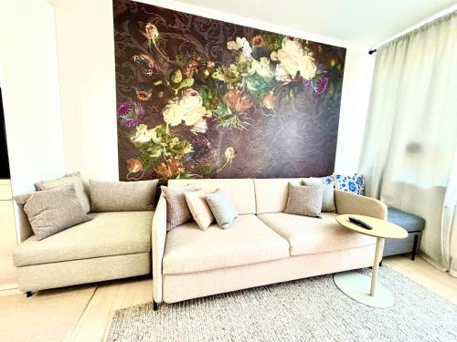 ein Wohnzimmer mit einem Sofa und einem Gemälde an der Wand in der Unterkunft Luxurious Boutique Apartment, inner city, next to Canals and Metro station in Kopenhagen