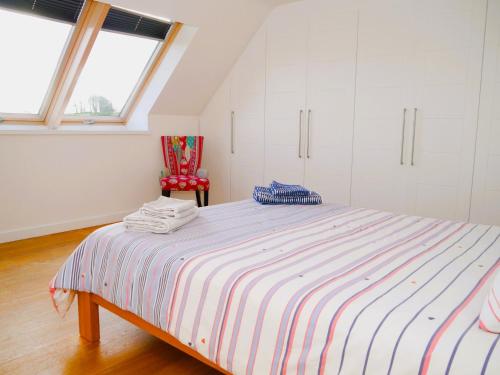 um quarto com uma cama grande e uma cadeira vermelha em The Longhouse em Castle Douglas