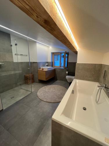 La grande salle de bains est pourvue d'une baignoire et d'une douche. dans l'établissement Haus Anna, à Großdorf