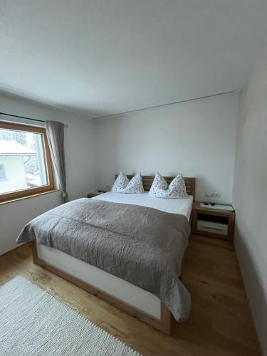 a white bedroom with a bed and a window at Haus Anna in Egg