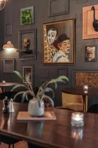 a dining room with a table and portraits on the wall at Best Western Plus Grand Hotel Elektra in Ludvika
