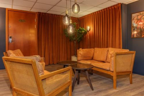 a living room with a couch and a table and chairs at Best Western Plus Grand Hotel Elektra in Ludvika