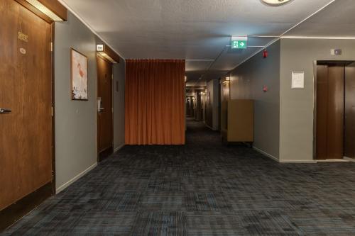 an empty hallway in an office building with an orange curtain at Best Western Plus Grand Hotel Elektra in Ludvika