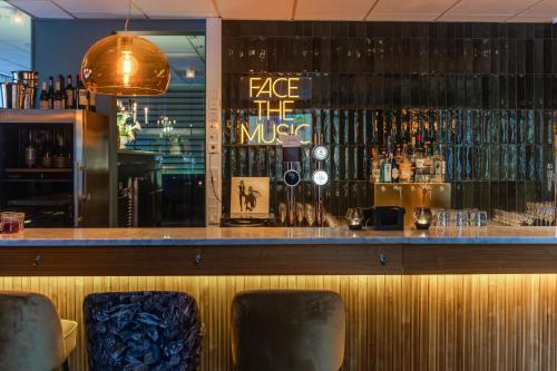 a bar with two chairs in front of a counter at Best Western Plus Grand Hotel Elektra in Ludvika