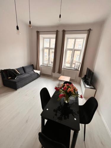 a living room with a table with flowers on it at Apartament 2 pokoje, Przemyśl, 1 piętro in Przemyśl