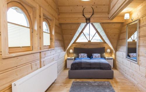 ein Schlafzimmer mit einem Bett in einem Holzhaus in der Unterkunft Domek VIP PIETIA in Zakopane