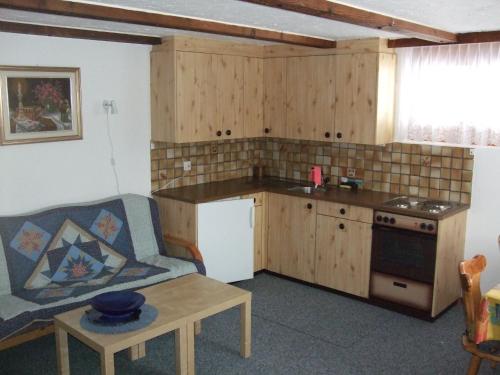 una cucina con divano e tavolo in una camera di Ferienhaus Bergfreund a Rosswald