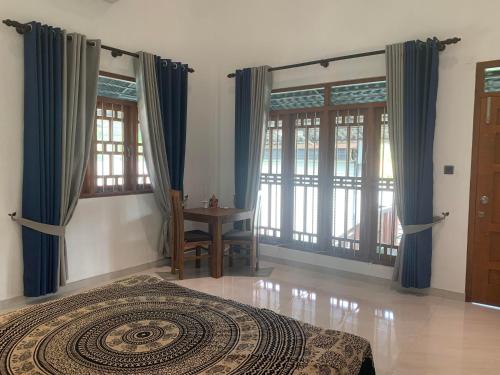 a bedroom with blue curtains and a bed and a table at Norwegian House in Bentota