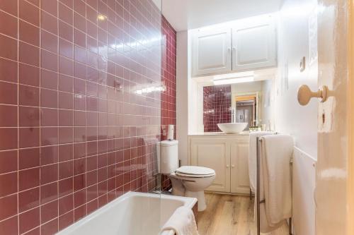 Un baño con bañera, inodoro y lavabo. en Portas da Sé Apartments, en Lisboa