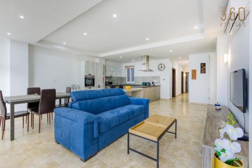un soggiorno con divano blu e tavolo di Top of the world 2BR home with spectacular views by 360 Estates a Mellieħa
