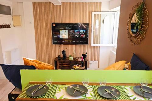 - un salon avec une table verte et des assiettes dans l'établissement Cap-vert Evasion *Centre-ville*Cap Occitanie*005, à Limoux