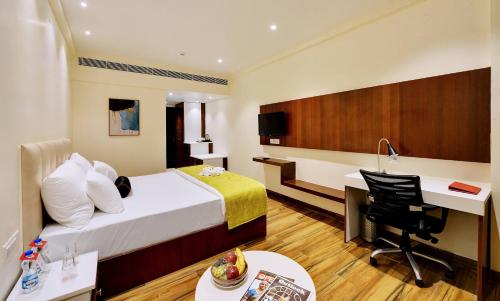 a hotel room with a bed and a desk at Mastiff Select Gulbarga Hotel in Gulbarga