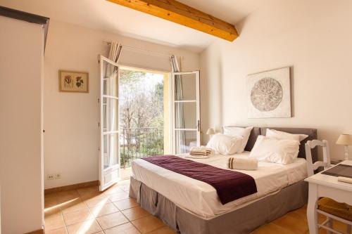 een slaapkamer met een bed en een groot raam bij Art du green villa N°10 - Maison avec piscine in La Motte