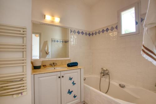 een witte badkamer met een bad en een wastafel bij Art du green villa N°10 - Maison avec piscine in La Motte