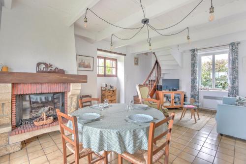 une salle à manger avec une table et une cheminée dans l'établissement La Esnaudière - Maison à moins d’un km du Rance, à Langrolay
